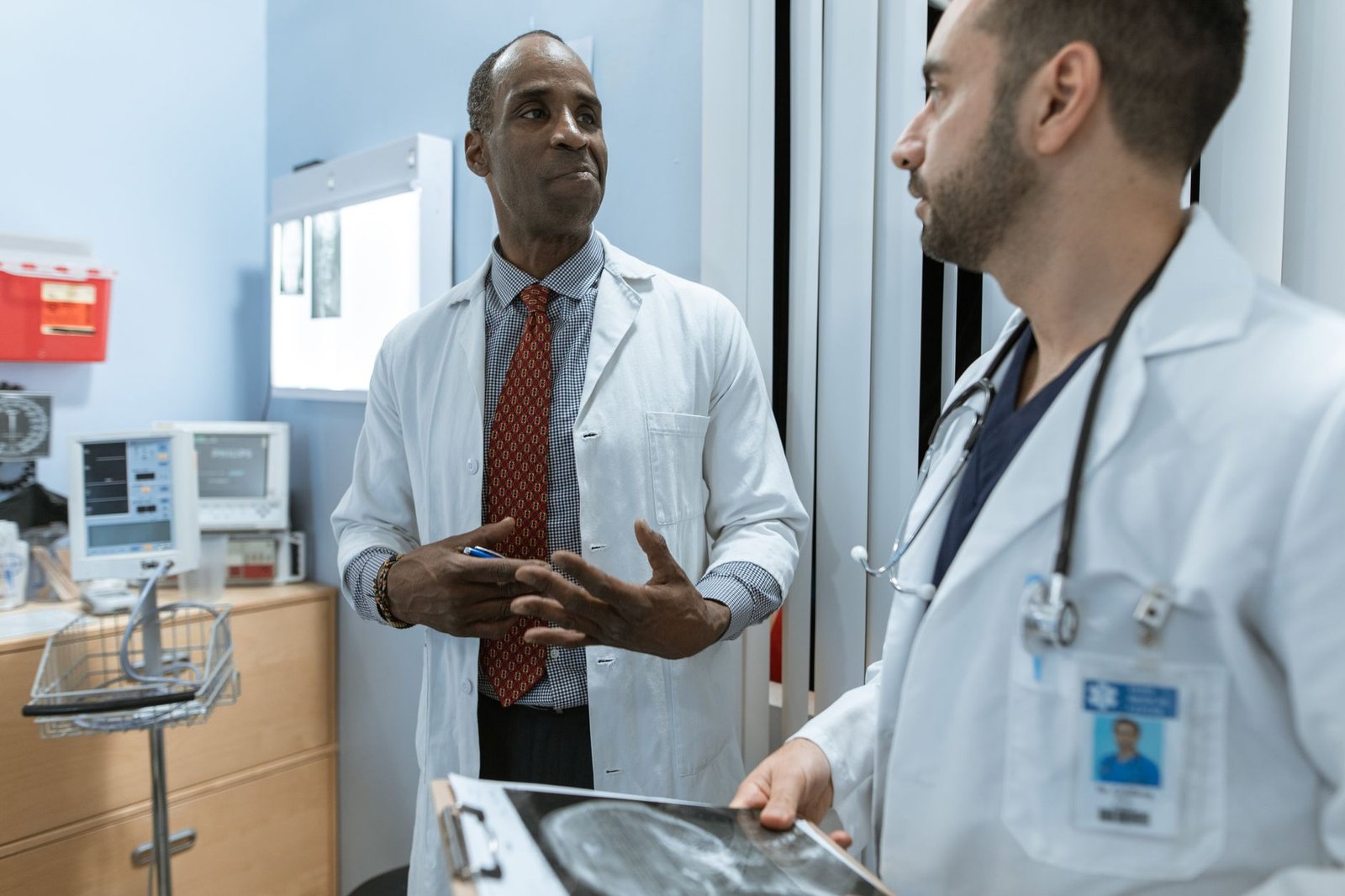 Older veteran discussing VA pain management for veterans with cancer with a physician in a bright clinic