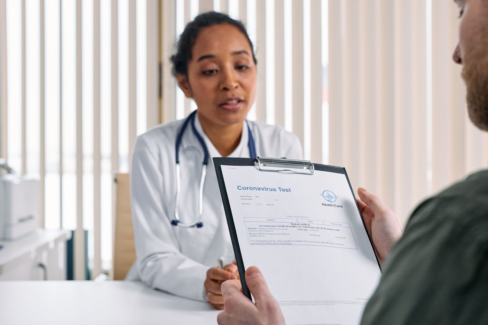 Physician explaining lung function results to a veteran and spouse in a bright clinic