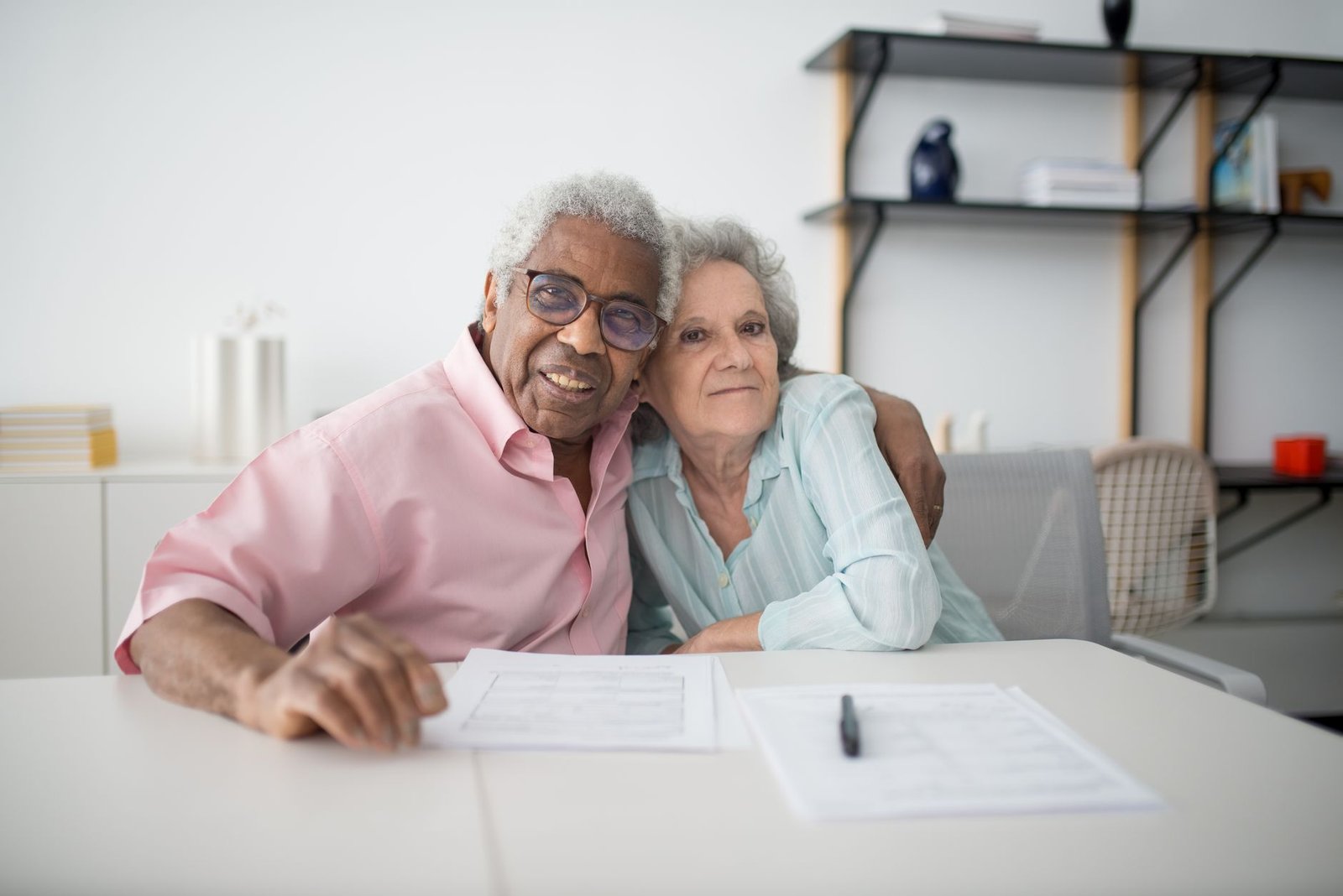 Veteran and spouse organizing employment records at home to document civilian shipyard work for a VA asbestos claim